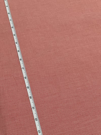 Red and white micro houndstooth check yarn-dyed fabric.