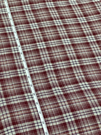 Maroon and off-white plaid yarn-dyed fabric with thin orange and purple lines.