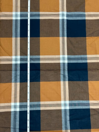 Navy, mustard and brown plaid yarn-dyed fabric, with whitish bands and fine dark lines.