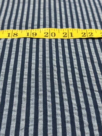 Navy and light bluish grey plain candy stripe yarn-dyed fabric with a puckered seersucker surface.