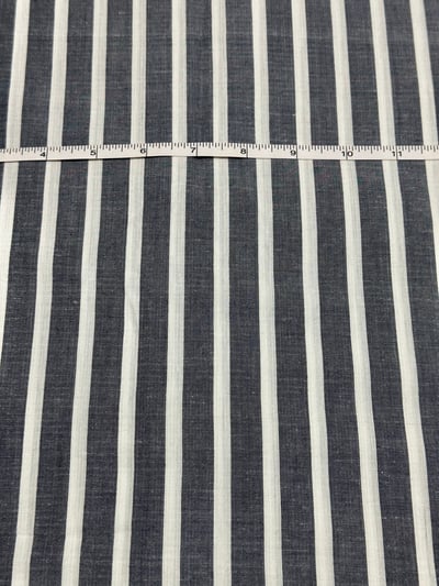Navy chambray and white multi stripe yarn-dyed fabric, with unequal stripe widths and visible slubs.